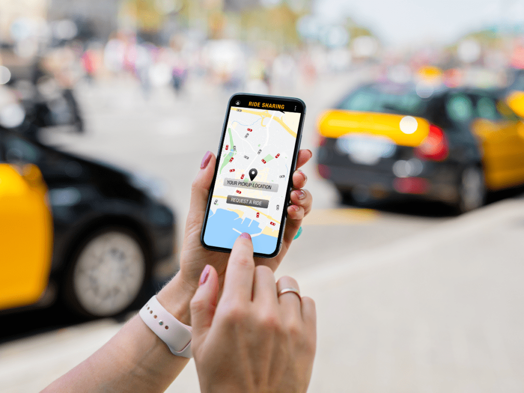 Someone holding a smartphone is requesting an uber on a busy street